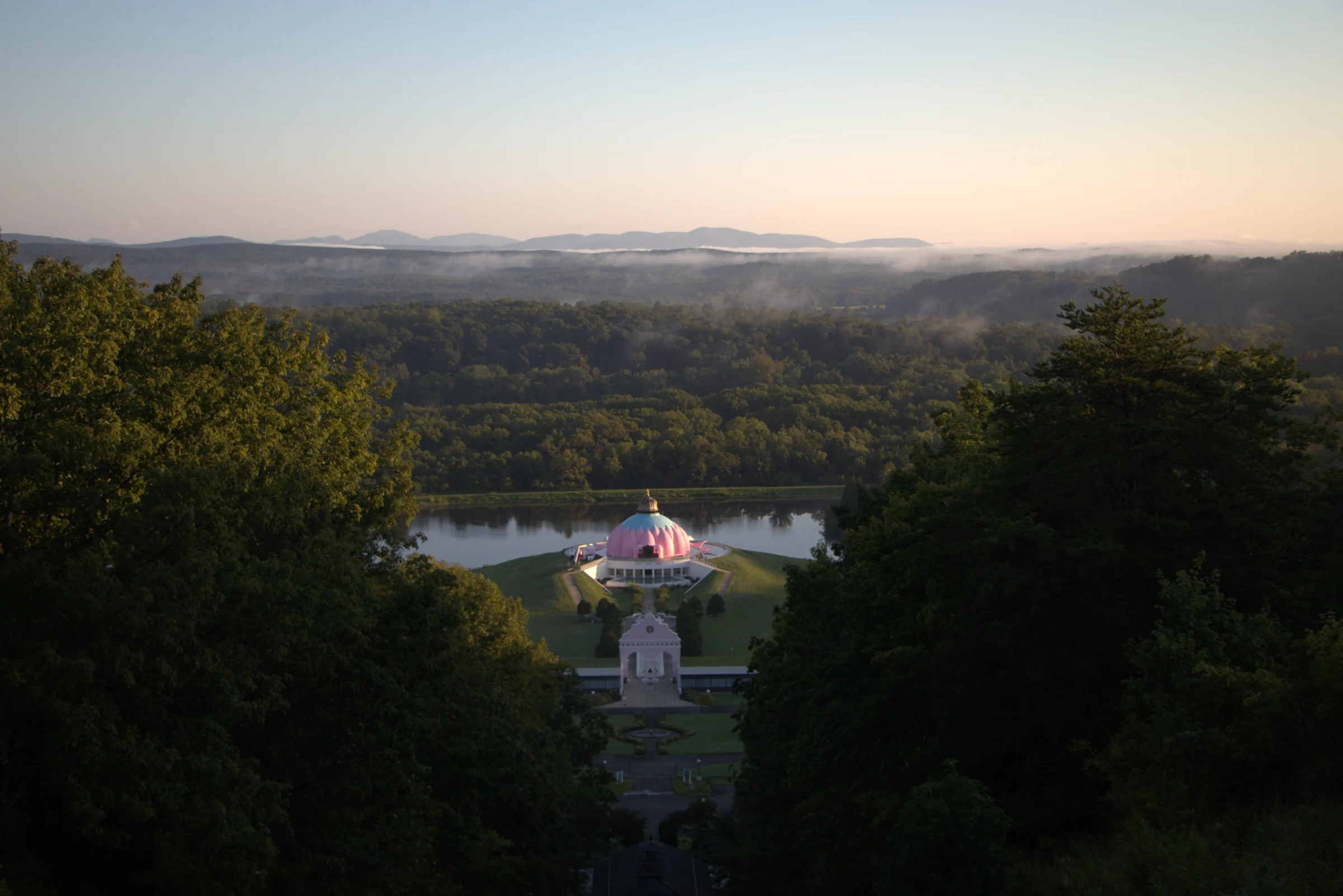 Lotus temple overlooking a misty forest at sunrise